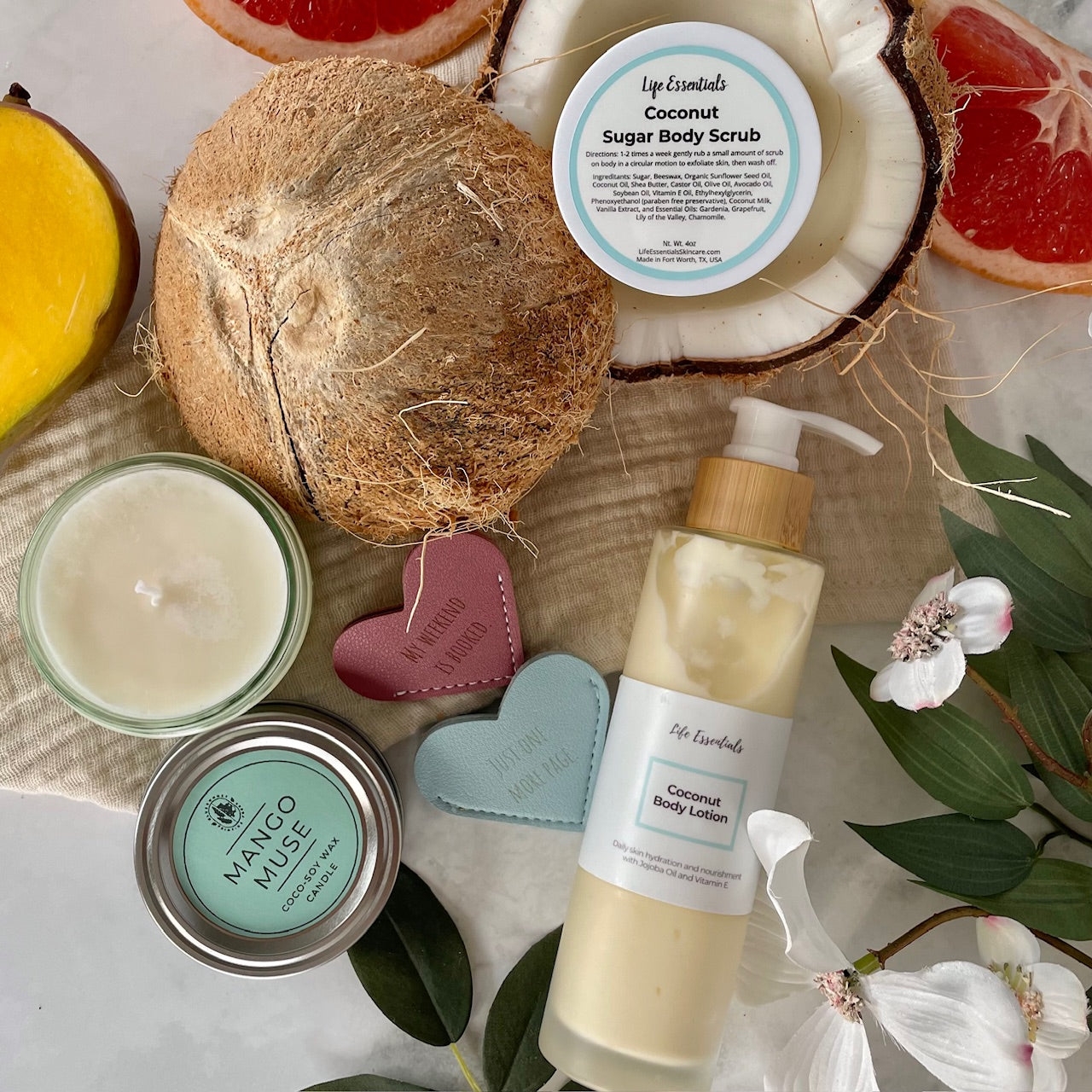 Nontoxic skincare products including a body scrub, lotion, and candles on a natural background with coconuts and flowers.