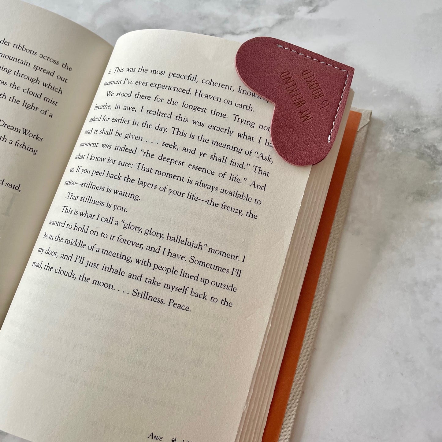 Open book with a leather bookmark on a textured surface